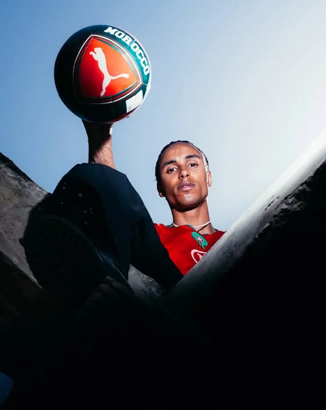 Low-angle portrait of a Morocco supporter balancing a branded football
