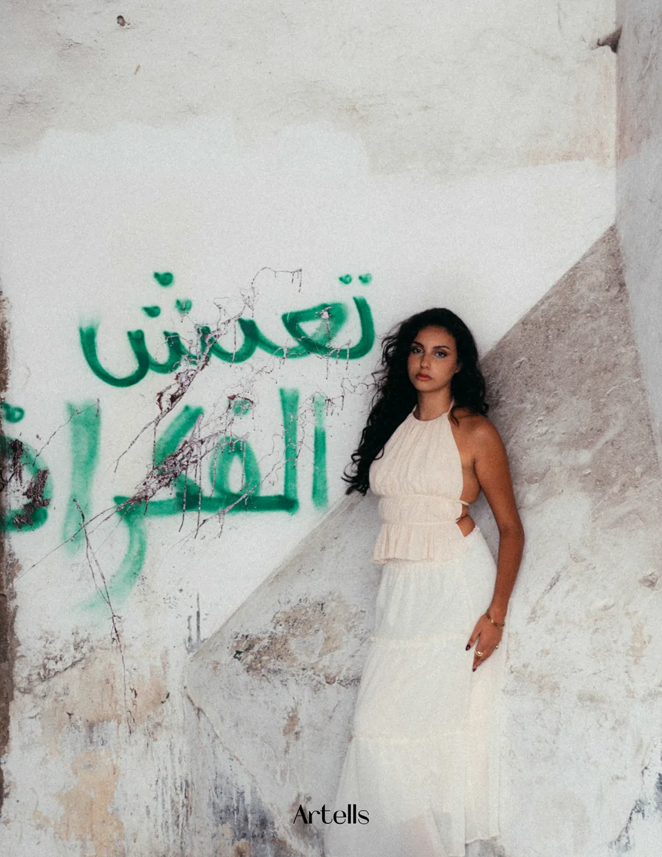 Artells portrait beside Arabic typography